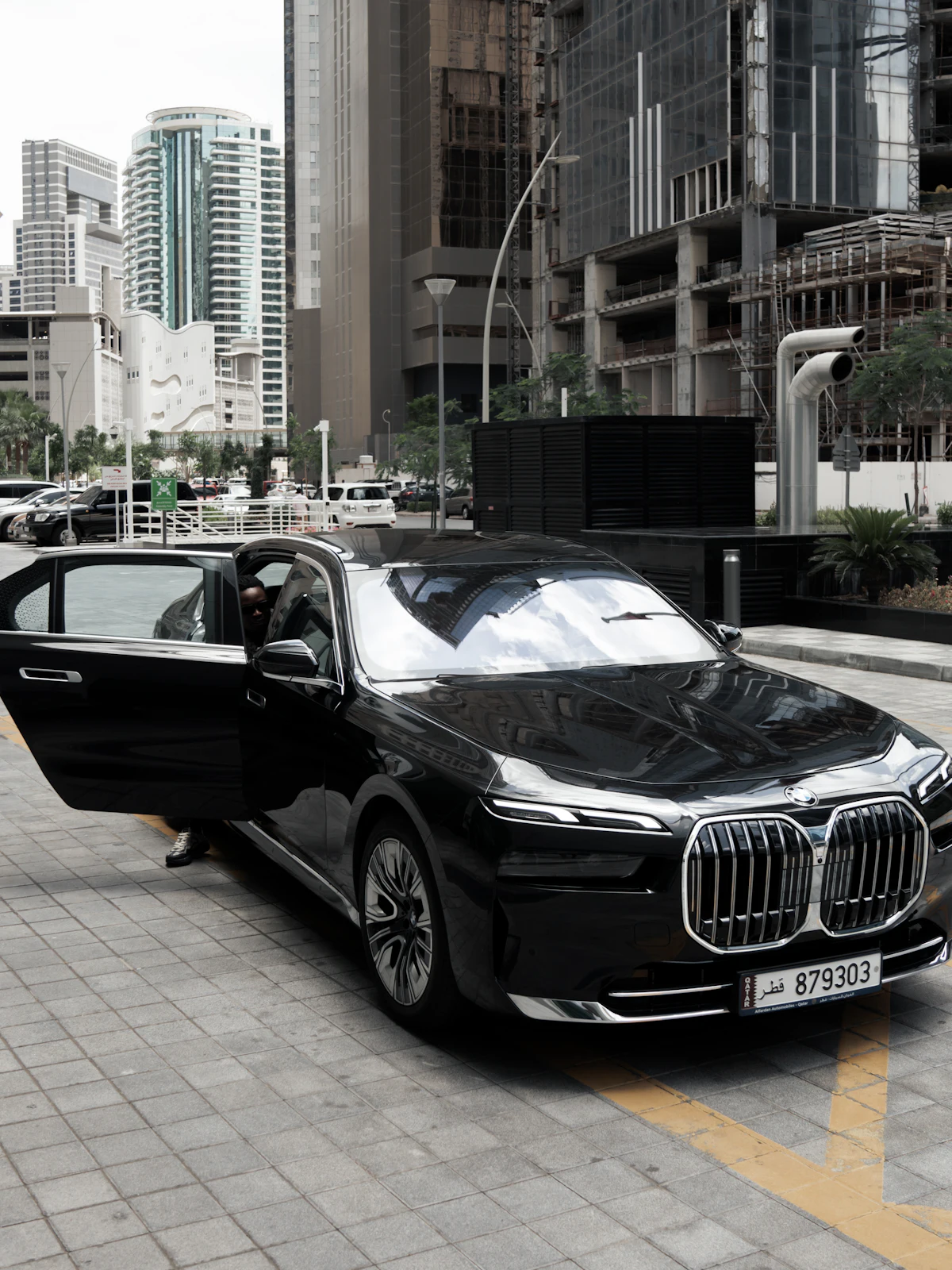 Black BMW 7 Series with its rear door open, ready for a passenger