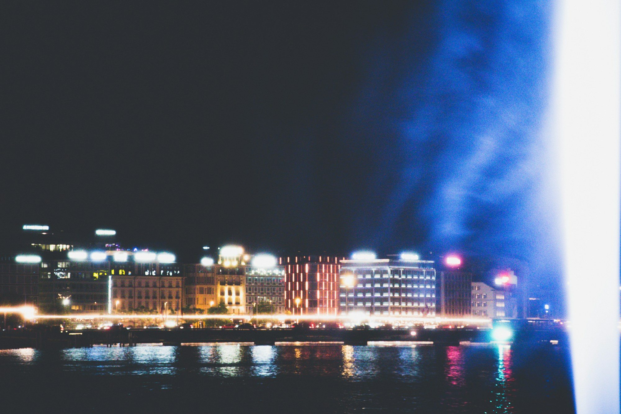 Geneva's lakefront lit up at night beside the Jet d'Eau fountain