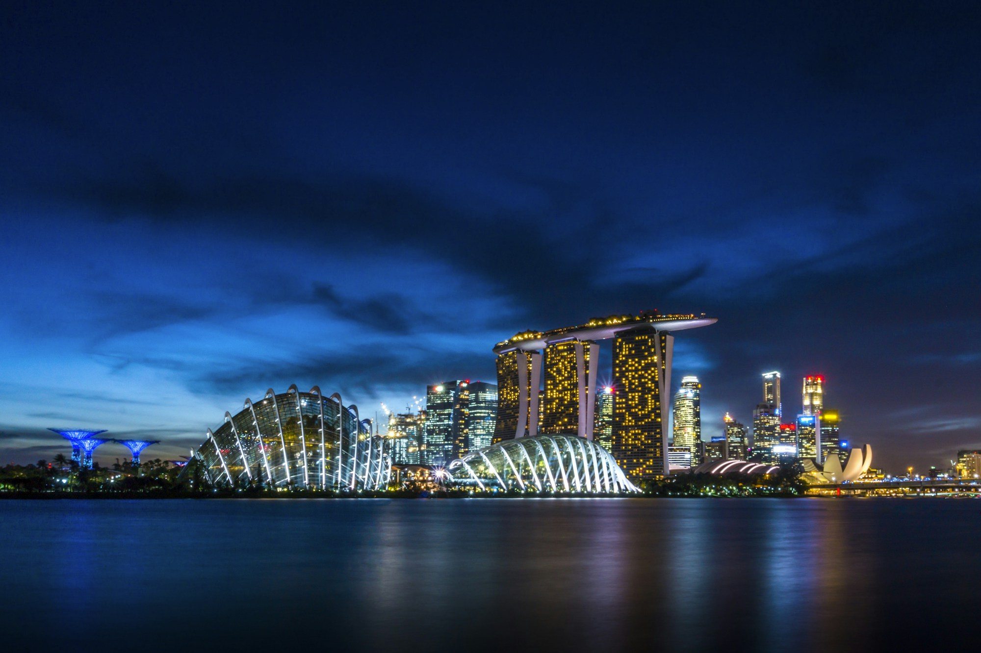 Marina Bay Sands and Gardens by the Bay lit up across the water at night