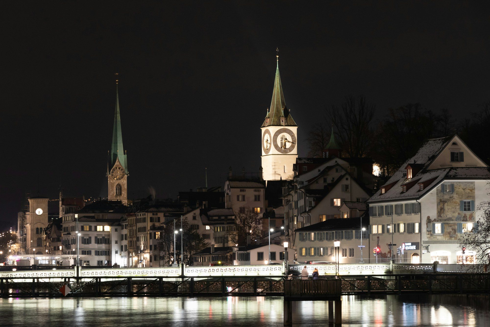 Zurich's old town and church spires lit up along the Limmat at night